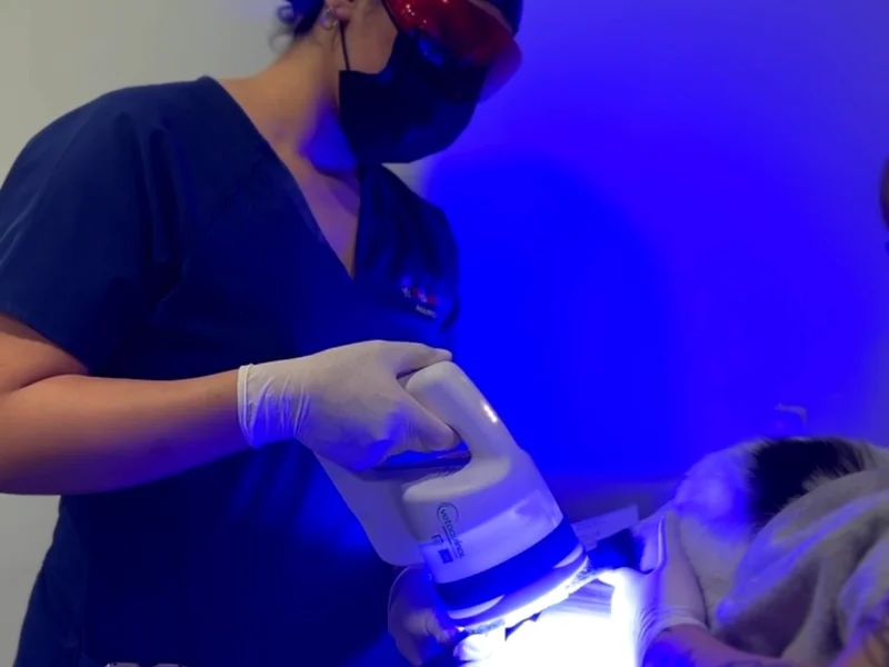 Médica veterinaria de Lomont® aplicando fotobiomodulación Phovia con luz azul sobre la piel de un paciente como terapia dermatológica complementaria